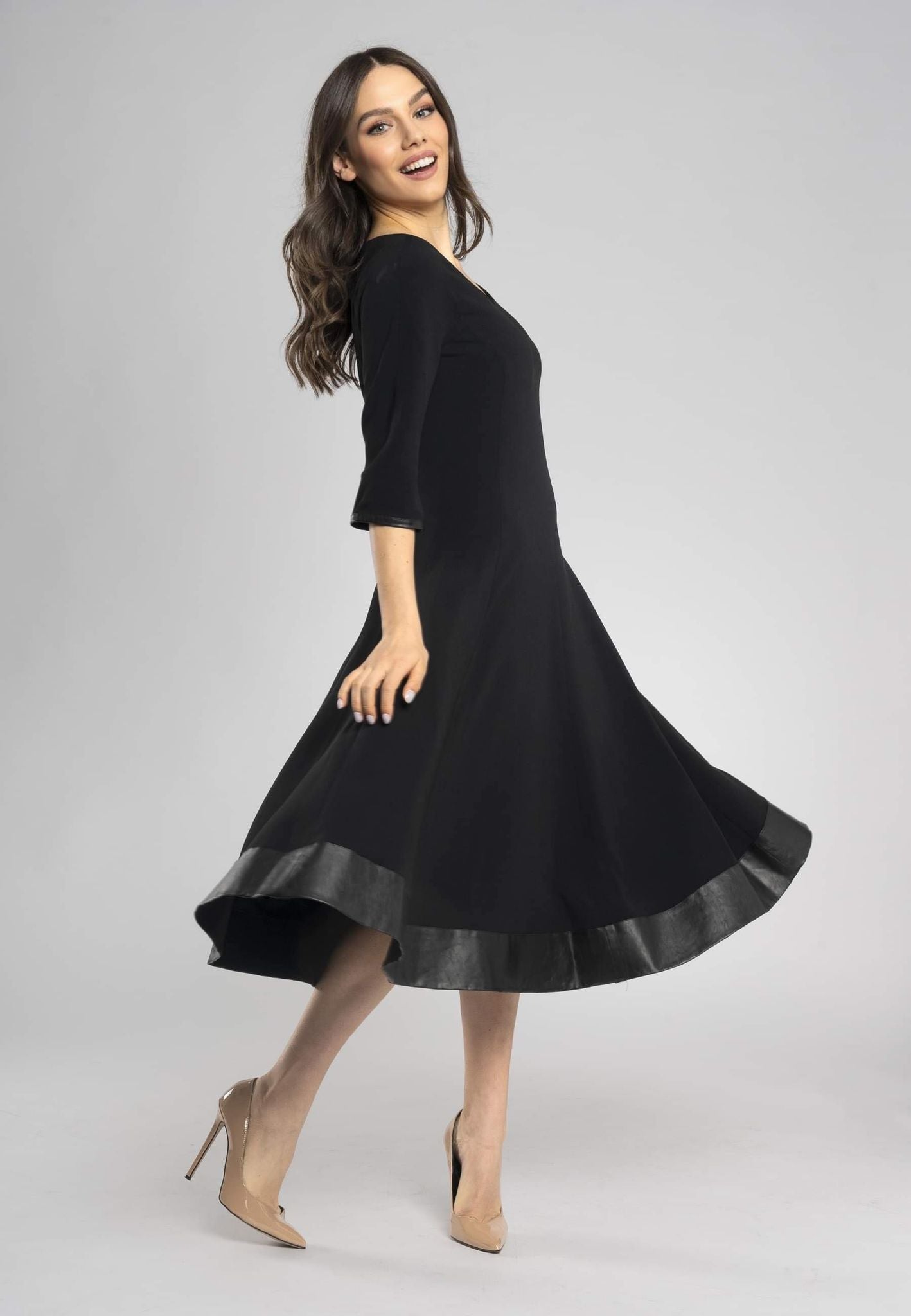Schwarzes Midikleid mit rundem Ausschnitt und halblangen Ärmeln. Raffinierter, minimalistischer Schnitt.